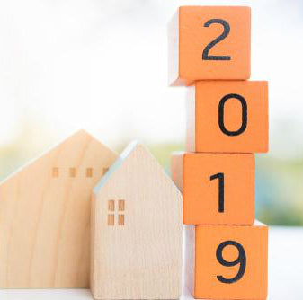 Orange blocks with numbers stacked next to a wooden house
