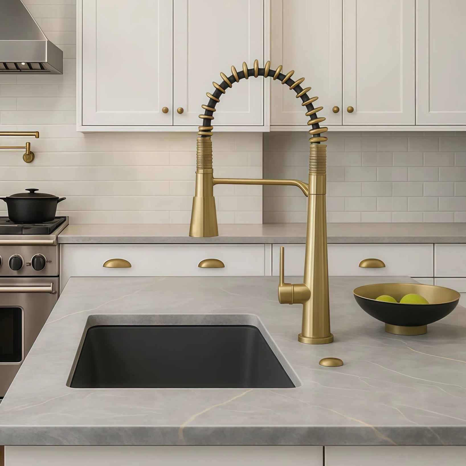 White kitchen with brass faucet and coordinating cabinet hardware with stainless steel appliances. 