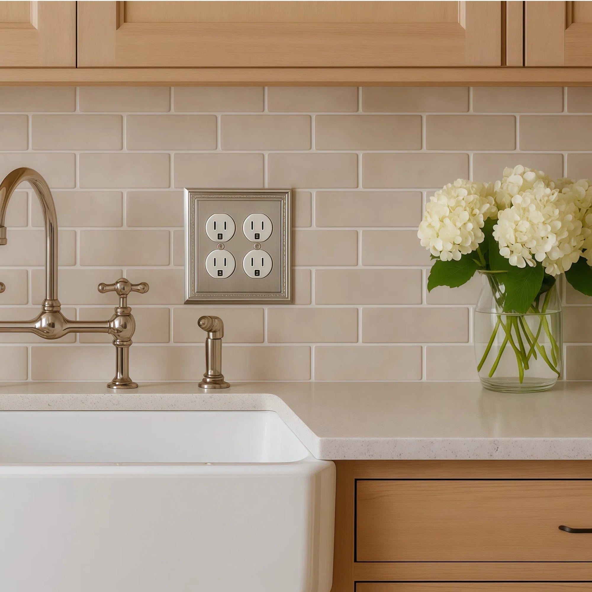 satin nickel wall outlet cover on a tan subway tile back splash in farmhouse modern kitchen