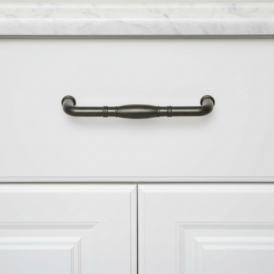 Graphite gray cabinet handle on a white cabinet with marble countertop