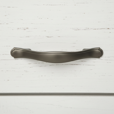 Graphite solid metal handle pull on a white wooden surface