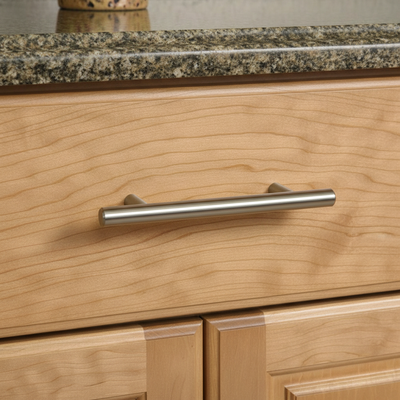 solid metal satin nickel cabinet pull handle on  a wood drawer