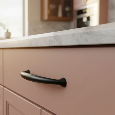 Close-up of a kitchen cabinet with a black handle and marble countertop.