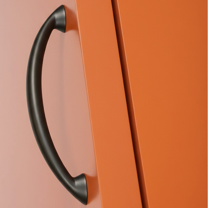 Black handle on an orange cabinet door