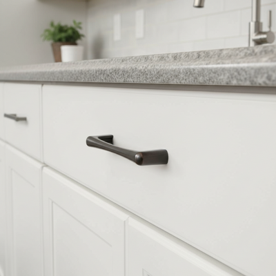 Close-up of a kitchen cabinet with a black handle on a white cabinet door.