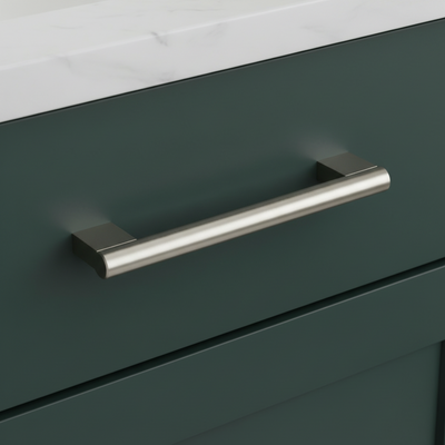 satin nickel handle on a green cabinet with a white countertop