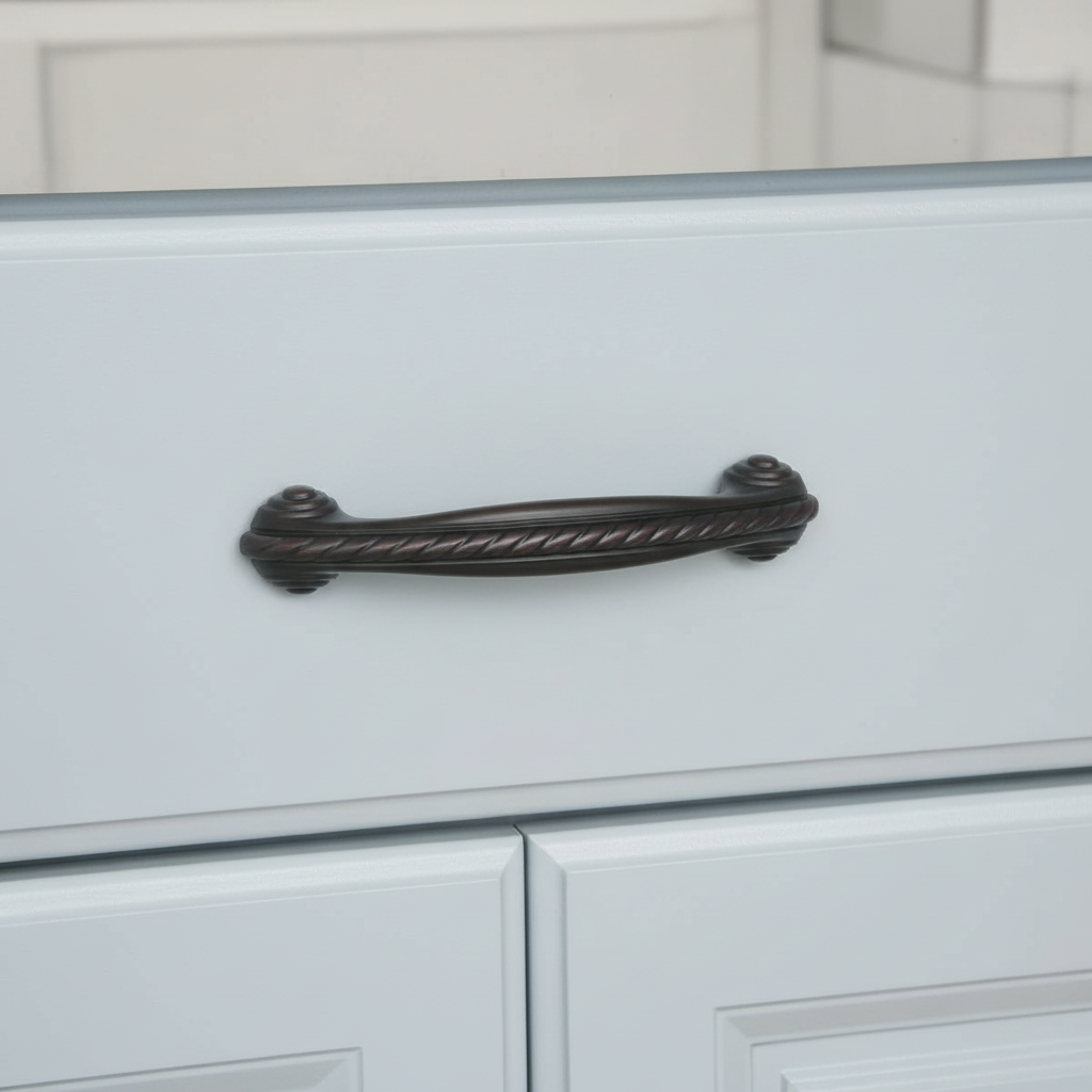 Oil rubbed bronze cabinet handle on a light gray cabinet with a blurred background
