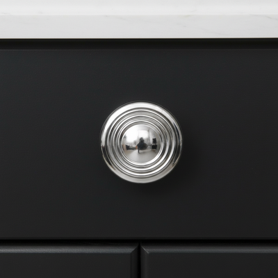 Close-up of a black cabinet with a silver knob