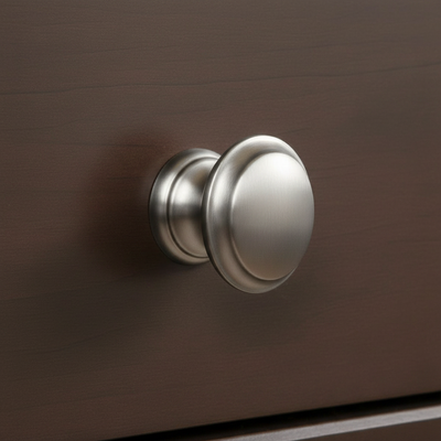 stain nickel round cabinet knob on a warm wood cabinet drawer 
