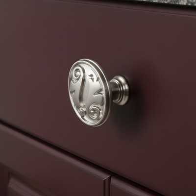 silver decorative cabinet knob on a burgundy drawer 