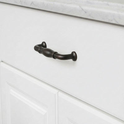 oil rubbed bronze cabinet handle on a white cabinet with marble countertop