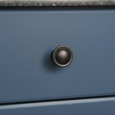 Close-up of a blue drawer with a bronze knob