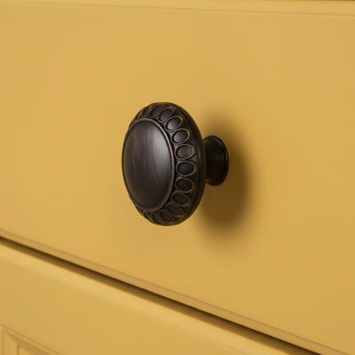 Decorative black door knocker on a mustard yellow door
