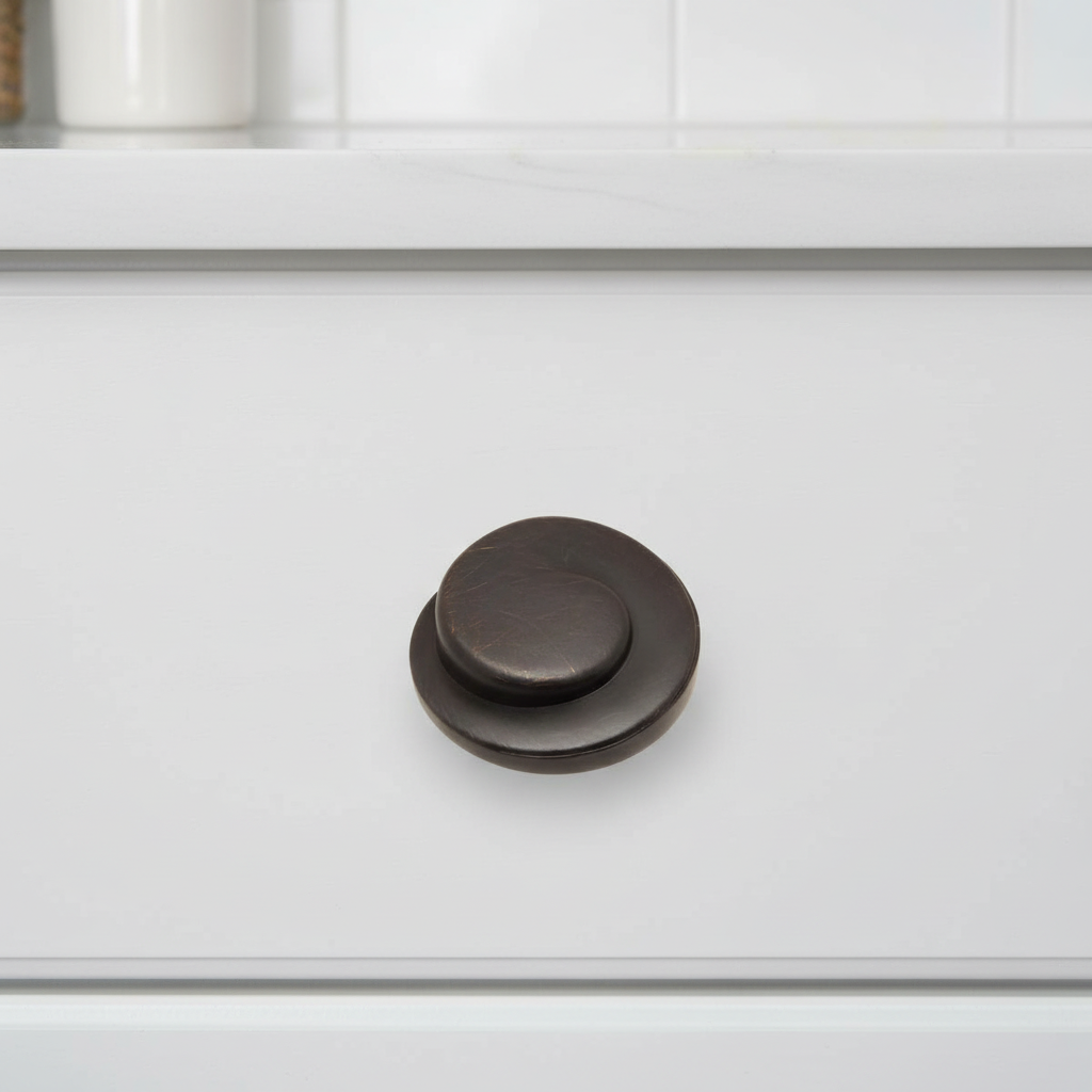 Dark brown cabinet knob on a white kitchen cabinet