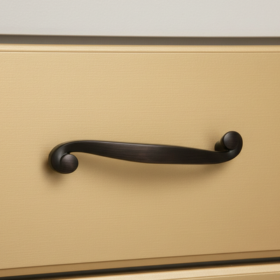 Close-up of a black cabinet handle on a beige drawer