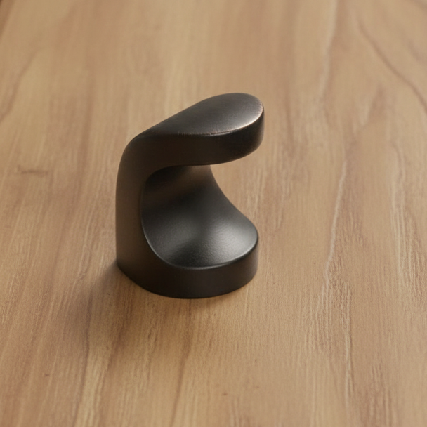 Black cabinet knob on a wooden surface