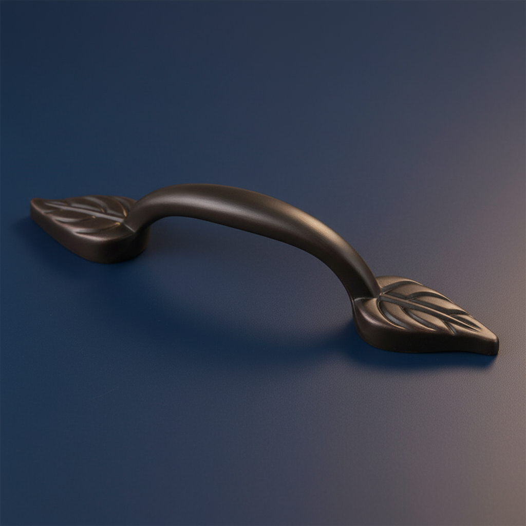 Decorative oil rubbed bronze cabinet handle with leaf design on a blue background