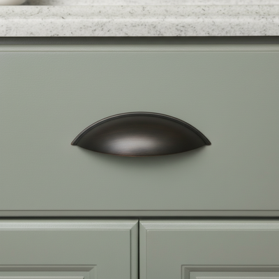 Green cabinet with a oil rubbed bronze handle on a kitchen counter