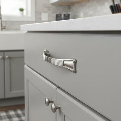 Close-up of a gray kitchen cabinet with a silver handle in a modern kitchen setting.