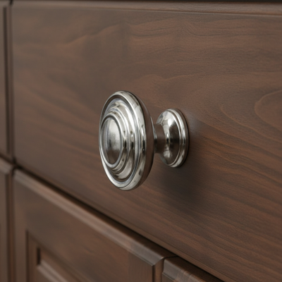 Polished chrome cabinet knob with two raised rings on the center on a white background