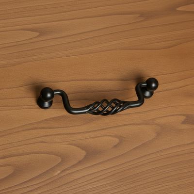 Black cabinet handle on a wooden surface