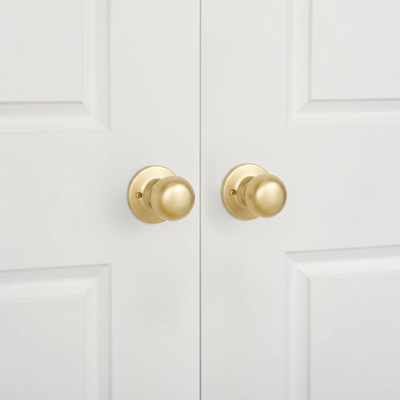 Designers impressions Bedford satin brass dummy door knobs installed on double closet doors