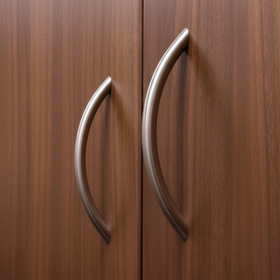 Close-up of two metallic handles on a wooden cabinet.