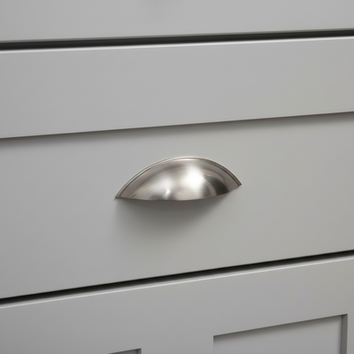 Close-up of a silver cabinet handle on a gray drawer