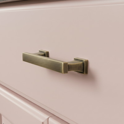 Brass cabinet handle on a pink cabinet door