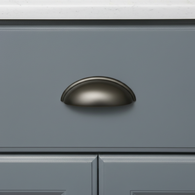 Graphite finish of cabinet cup pull on a blue cabinet drawer