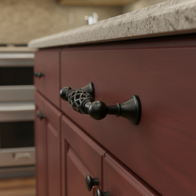 Black cabinet handle with intricate design on a white background