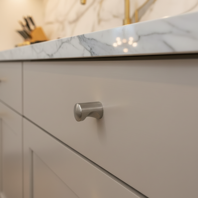 Close-up of a kitchen cabinet with a marble countertop and blurred background