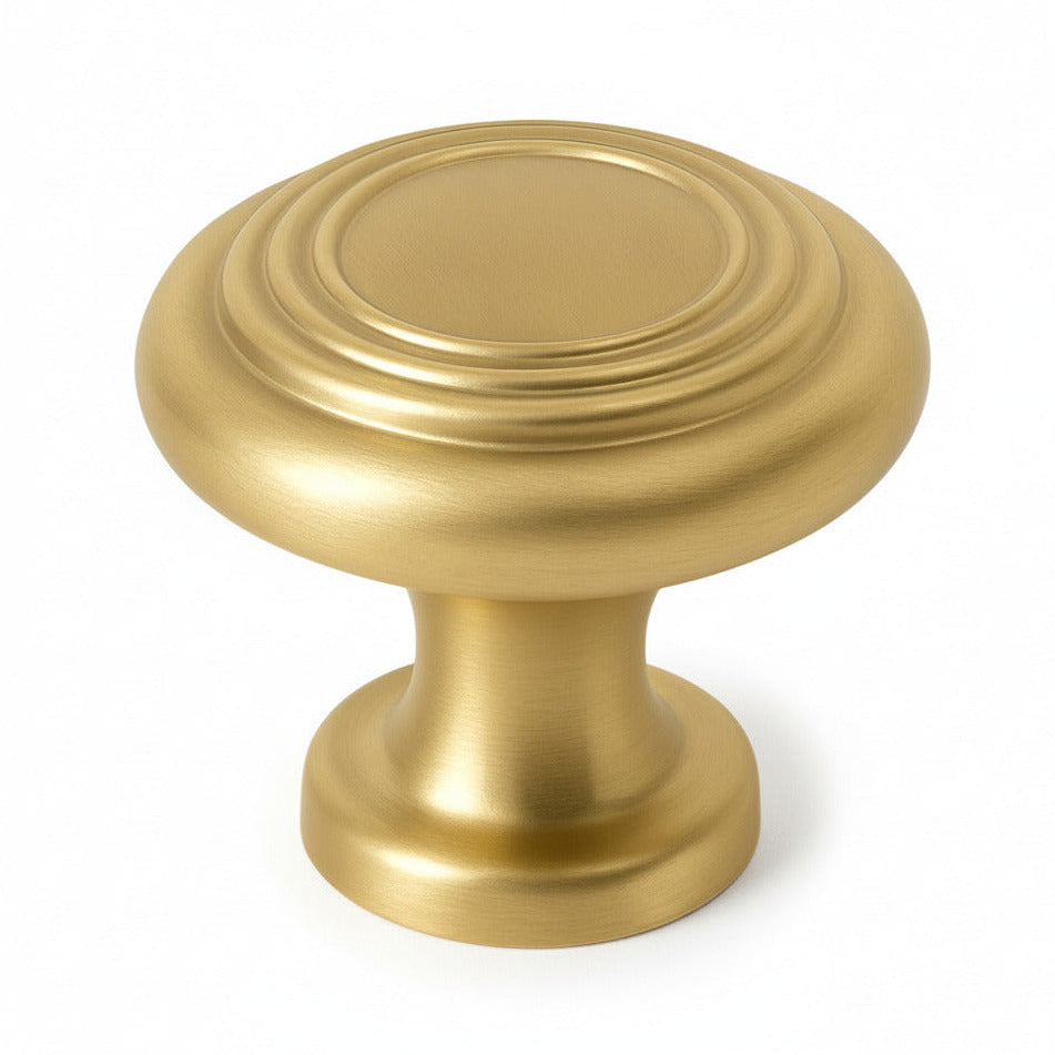 Brushed brass cabinet knob on a white background