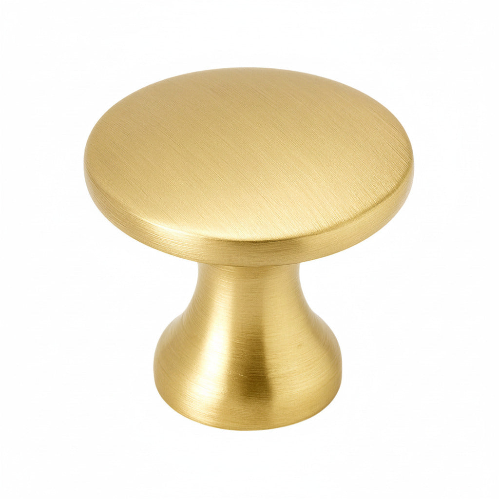 Small brushed brass cabinet knob on a white background
