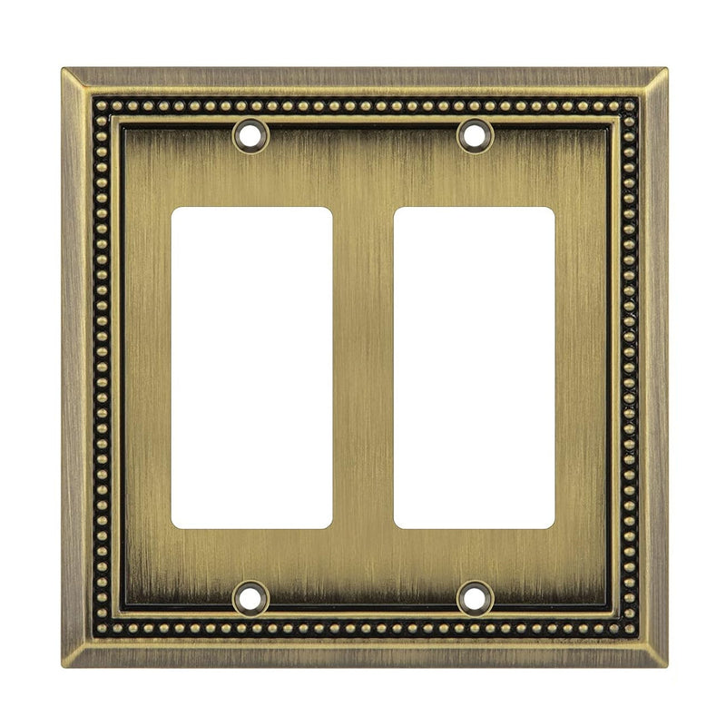 Double gang brass wall plate with decorative border on a white background