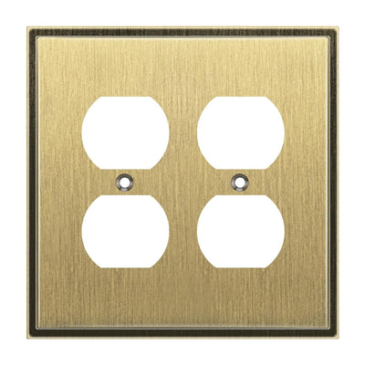 Antique brass electrical outlet cover with four white sockets on a white background