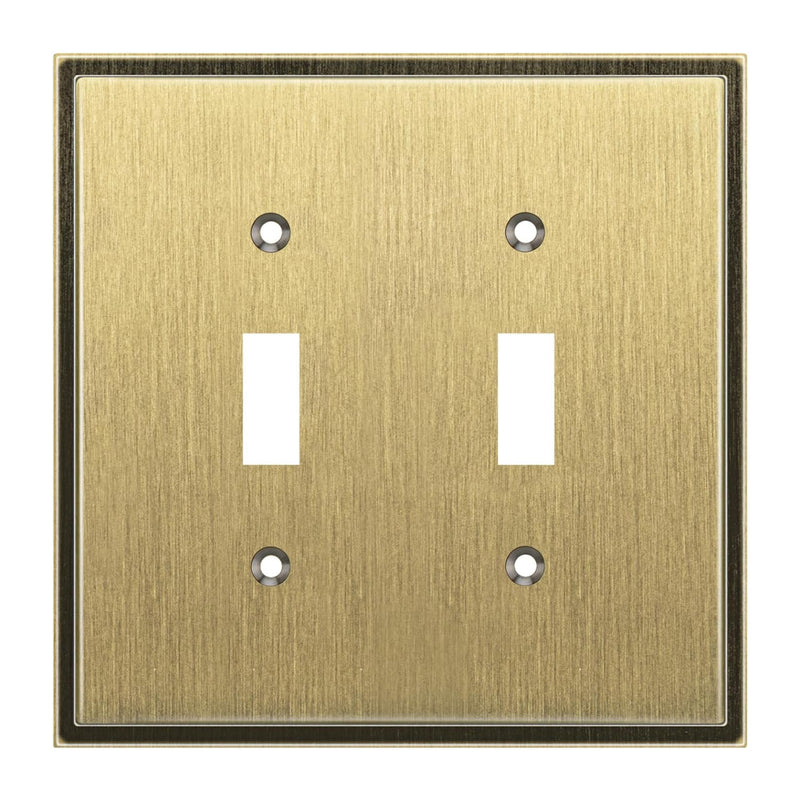 Double toggle switch plate with antique brass finish on a white background