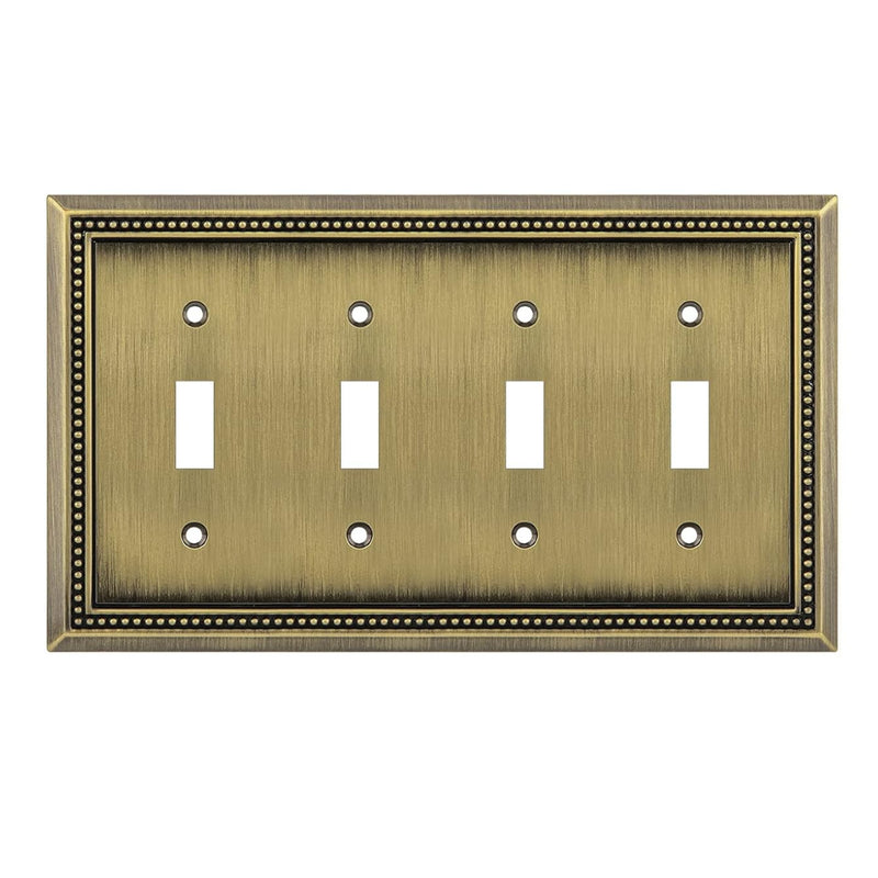 Antique brass four-toggle switch plate with decorative border on a white background