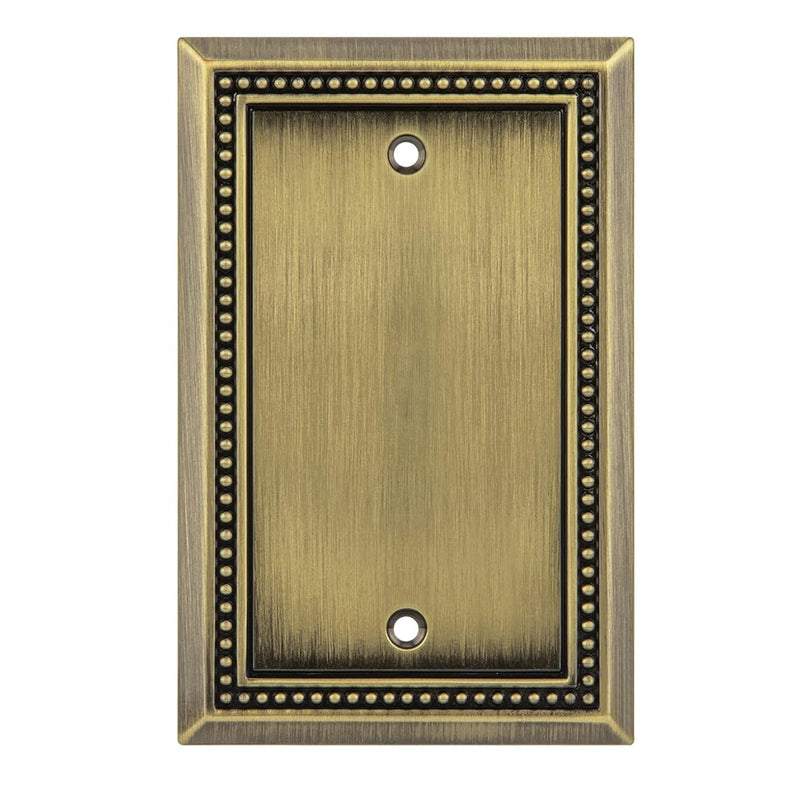 Antique brass blank wall plate with decorative border on a white background