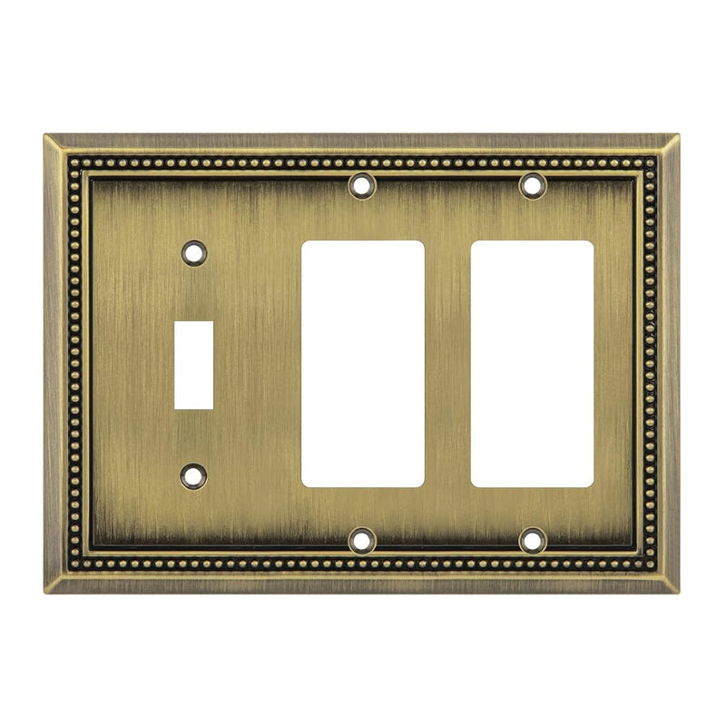 Decorative antique brass switch plate with three outlets on a white background