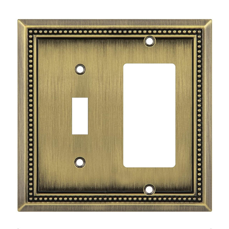Decorative brass wall plate with two switch sockets on a white background