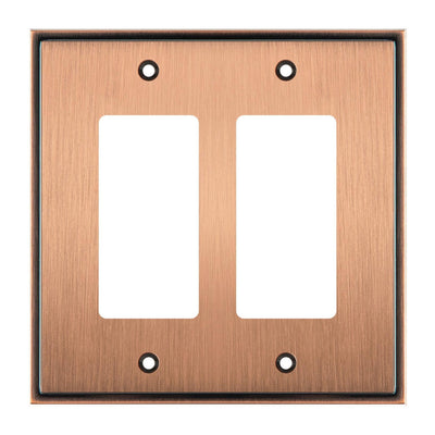 Copper double gang wall plate with two white inserts on a white background