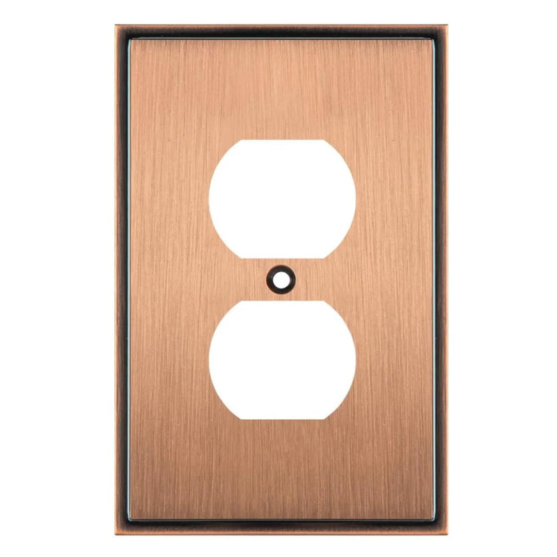 Copper electrical outlet cover with two sockets on a white background