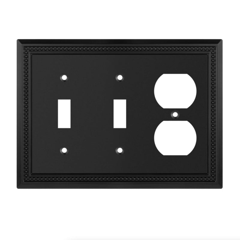 Black switch plate with white symbols for light switch and outlet on a white background