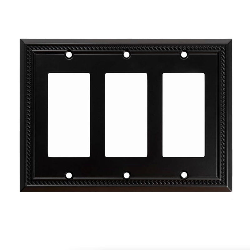 Black three-gang wall plate with white inserts on a white background
