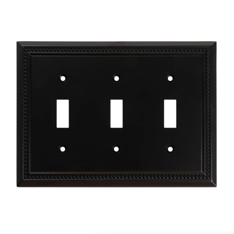 Black switch plate with three toggle switches on a white background