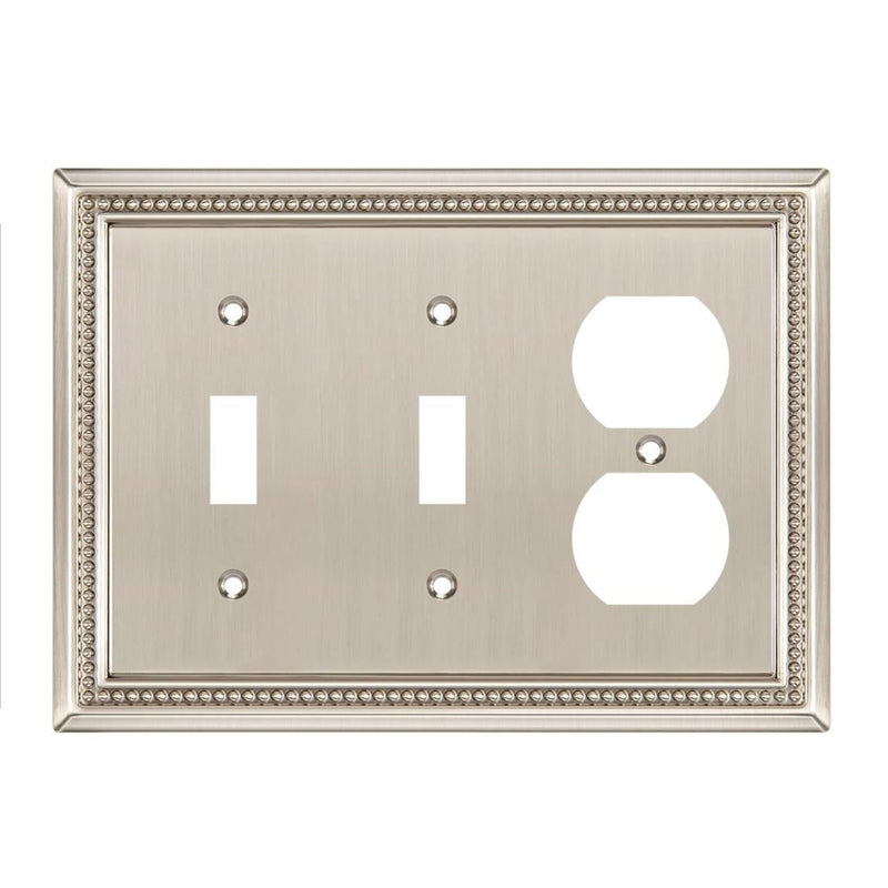 Decorative metal wall plate with two toggle switches and one outlet on a white background