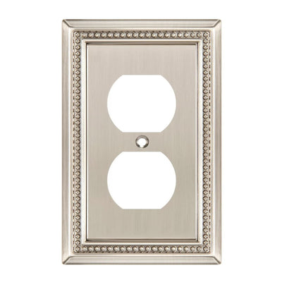 Decorative wall outlet cover with ornate border on a white background