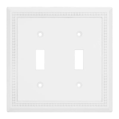 White double toggle switch plate with decorative border on a white background