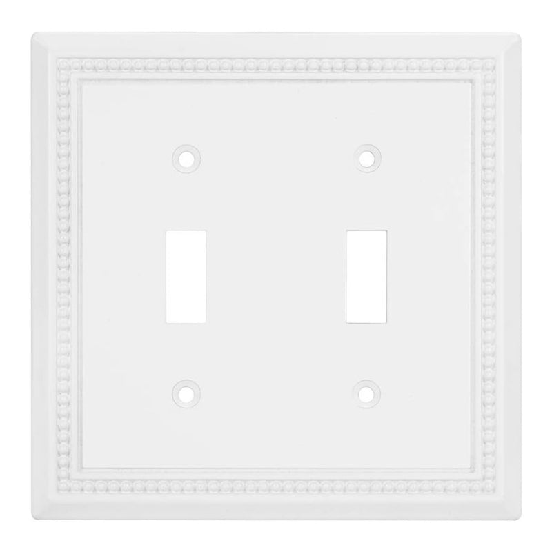 White double toggle switch plate with decorative border on a white background